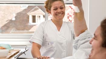 Une infirmière et un patient se regardent et sourient