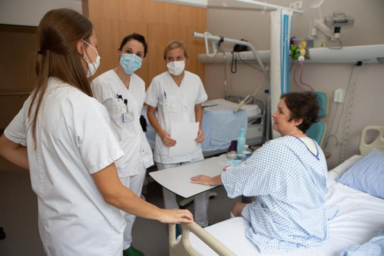 Des soignants avec une patiente suivant le parcours de réhabilitation améliorée après chirurgie.